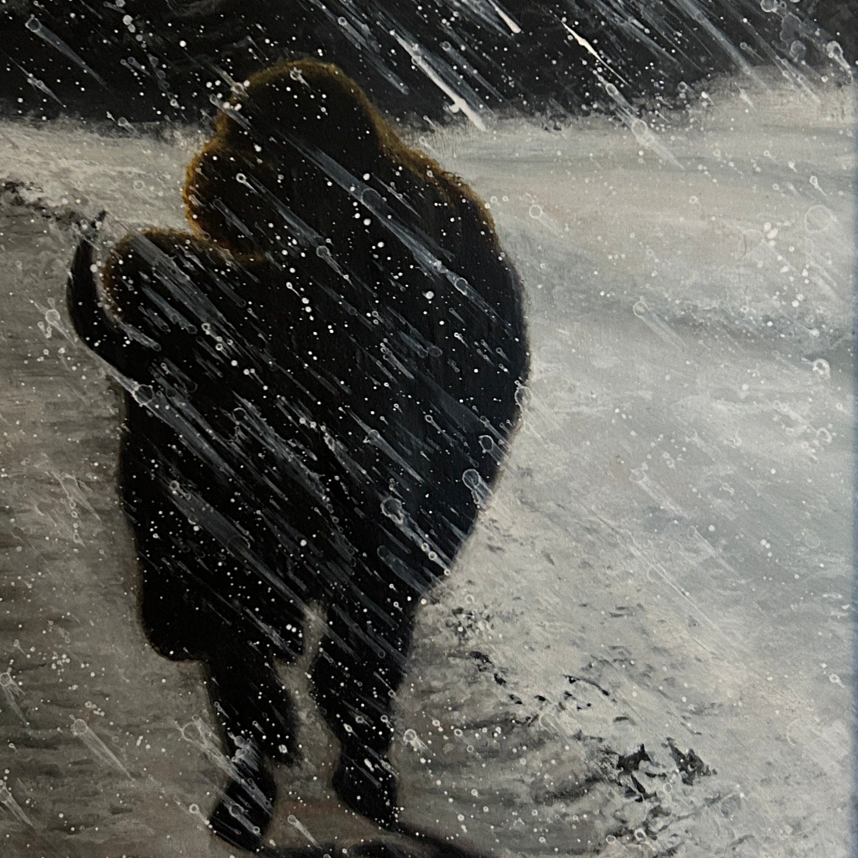 A framed artwork featuring a bison in a snowstorm, with a wooden frame.